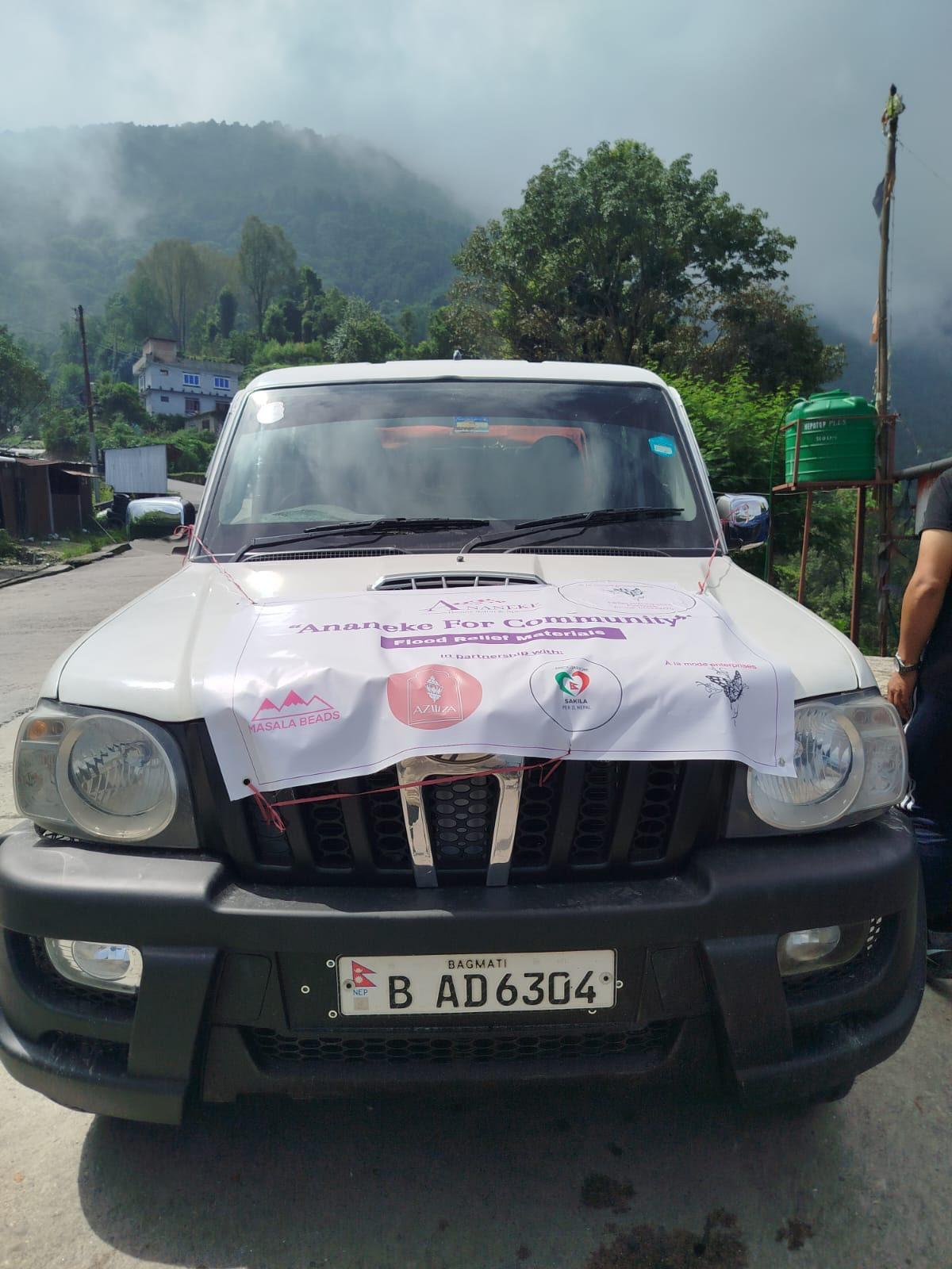 Fuoristrada con lo striscione «Flood Relief Materials» e il logo di Sakila per il Nepal